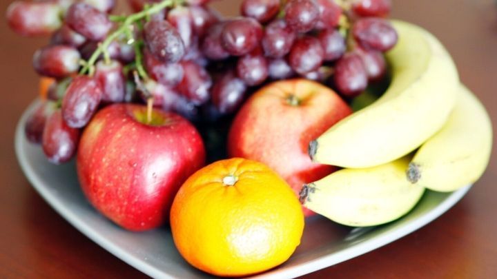 Ein Herz-fruchtiger Obstteller zeigt gekochte Trauben, &Auml;pfel und Bananen, die zur Schnapsherstellung genutzt werden k&ouml;nnten.