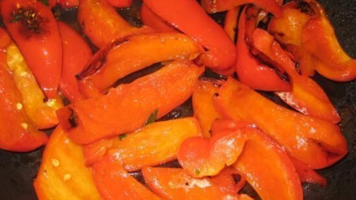 Gebratene Paprikastreifen liegen in einer Pfanne, umgeben von k&ouml;stlichem &Ouml;l, bereit zum Servieren.