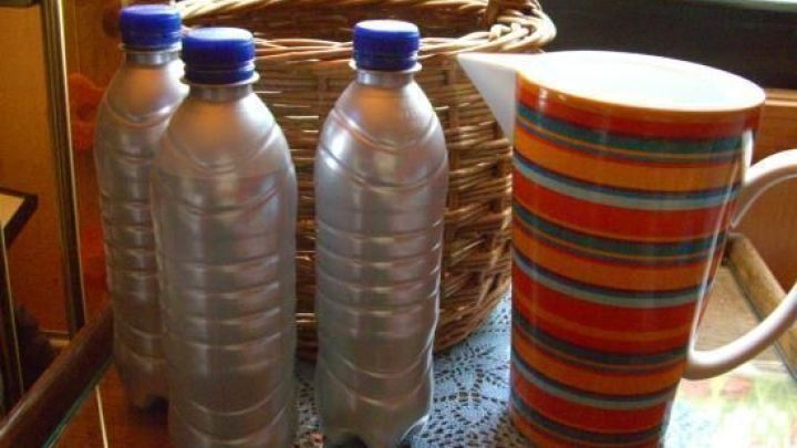 Drei Wasserflaschen stehen neben einem bunten Krug auf einem Tisch, was die Bedeutung des Trinkens unterstreicht.