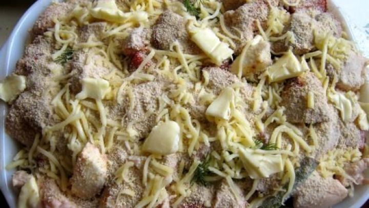 Gebackene H&uuml;hnerbrustfiletst&uuml;ckchen sind mit K&auml;se und Gew&uuml;rzen &uuml;berbacken und warten in einer Auflaufform auf den Servierzeitpunkt.