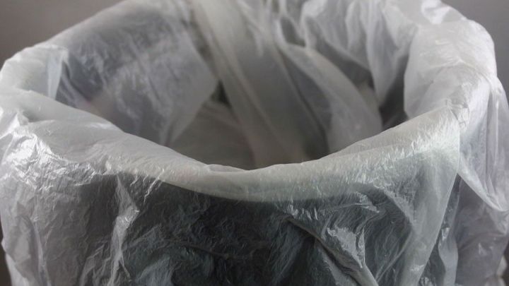 Ein transparenter Obst- und Gem&uuml;sebeutel ist im Kosmetikeimer platziert, bereit zur Wiederverwendung f&uuml;r Abf&auml;lle.