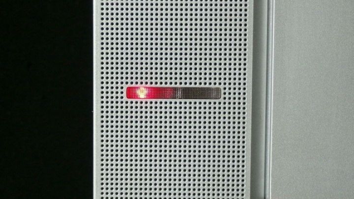 Ein Stromsparger&auml;t zeigt ein rotes Licht an, was auf Stand-By-Verluste hinweist, w&auml;hrend es an der Wand montiert ist.