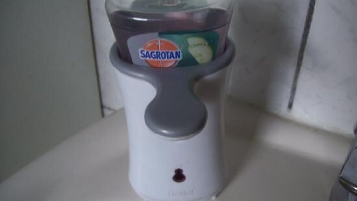 Seifenspender gibt Seife in Badezimmer ab; enth&auml;lt lila Nachf&uuml;llung von SAGROTAN.