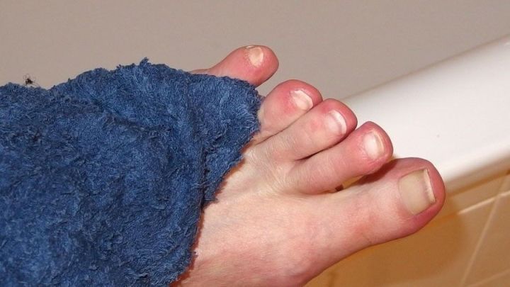 Ein Fu&szlig;, eingewickelt in ein Handtuch, ber&uuml;hrt die Badewanne, er vermittelt das Thema Fu&szlig;pflege und Hygiene.
