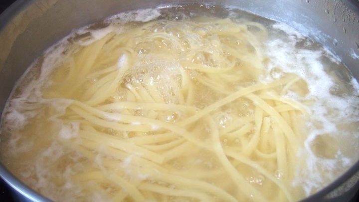 D&uuml;nne Spaghetti kochen in einem Topf mit sprudelndem Wasser auf dem Herd, ein Beispiel f&uuml;r effizientes Kochen.