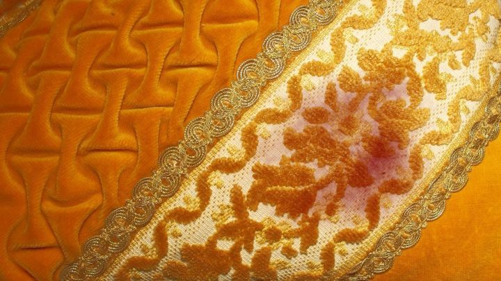 Ein elegantes, orangefarbenes Stoffmuster mit einem auff&auml;lligen Rotweinfleck, der entfernt werden soll.