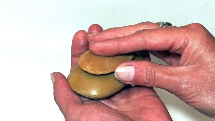 Zwei H&auml;nde halten eine Seife, w&auml;hrend sie diese sanft reiben, um den Schaum zu erzeugen und Wasser zu sparen.