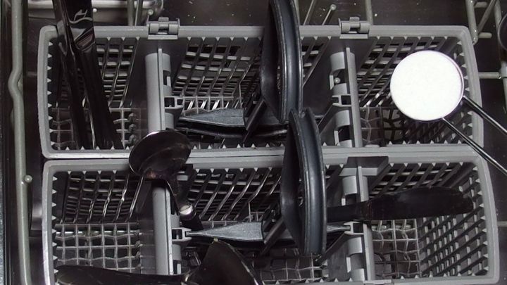 In einem Geschirrsp&uuml;ler sind schwarze Kochutensilien in den K&ouml;rben angeordnet, bereit zum effizienten Wasser sparen beim Sp&uuml;len.