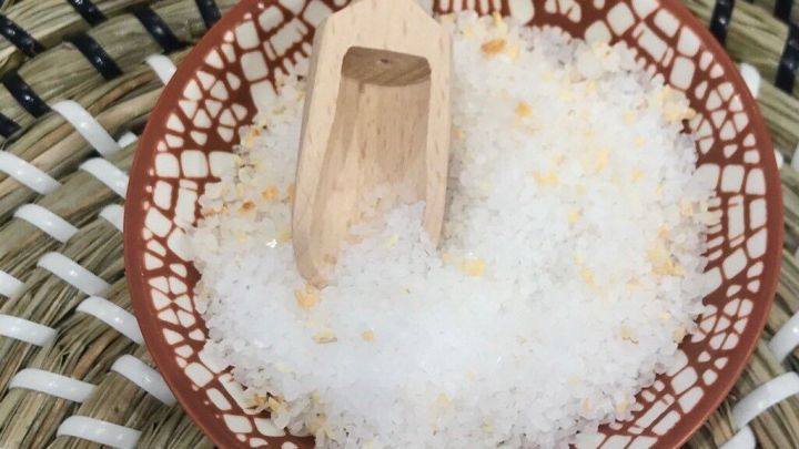 Eine Schale mit Selleriesalz, darin ein Holzl&ouml;ffel, liegt auf einem geflochtenen Untergrund.