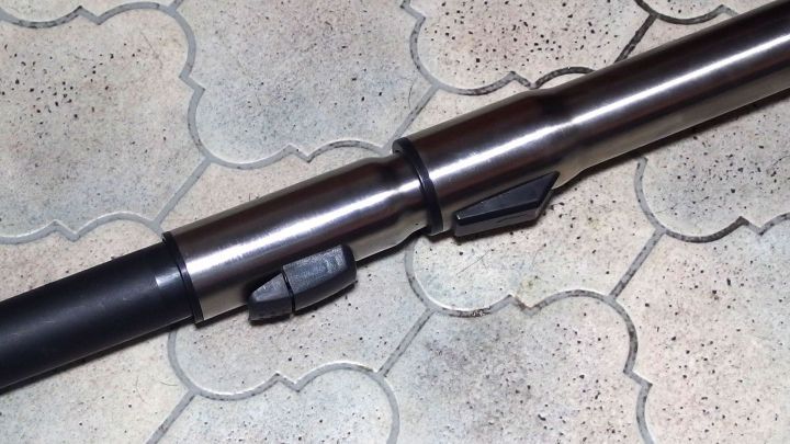 Das Staubsaugerrohr liegt auf einem gefliesten Boden und zeigt, dass es klemmt, was eine Reinigung erschwert.