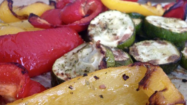 Geschmorte Paprika und Zucchini liegen farbenfroh auf einem Teller, leicht angebraten, bereit zum Servieren.