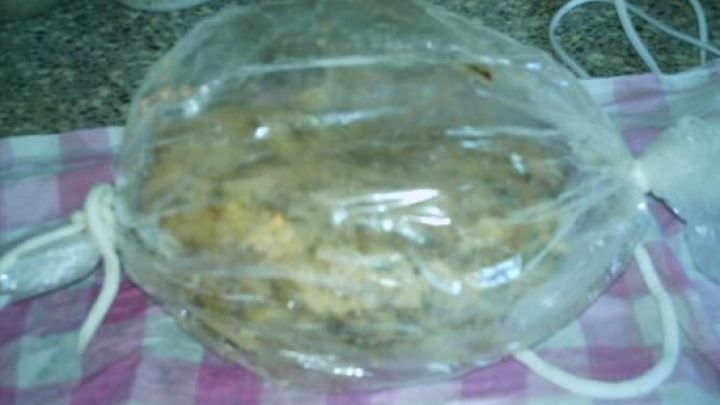 Ein Kn&ouml;del aus Champignons liegt in einer durchsichtigen Plastikh&uuml;lle auf einem karierten K&uuml;chentuch, bereit zum Servieren.