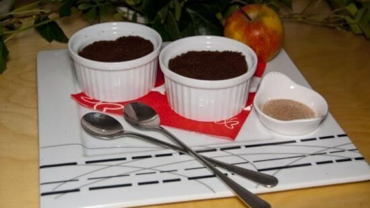 Zwei wei&szlig;e Schalen mit M&uuml;nsterl&auml;nder Bettelmann stehen auf einem schlichten Teller, umgeben von Besteck und einer Apfel.