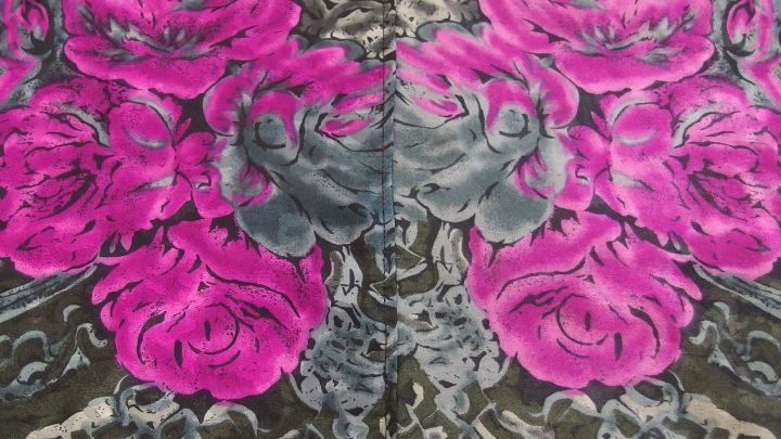 Bl&uuml;hende, lila Rosen auf einem grauen Hintergrund zieren die farbige W&auml;sche und zeigen die Wichtigkeit des Ausbleichens.