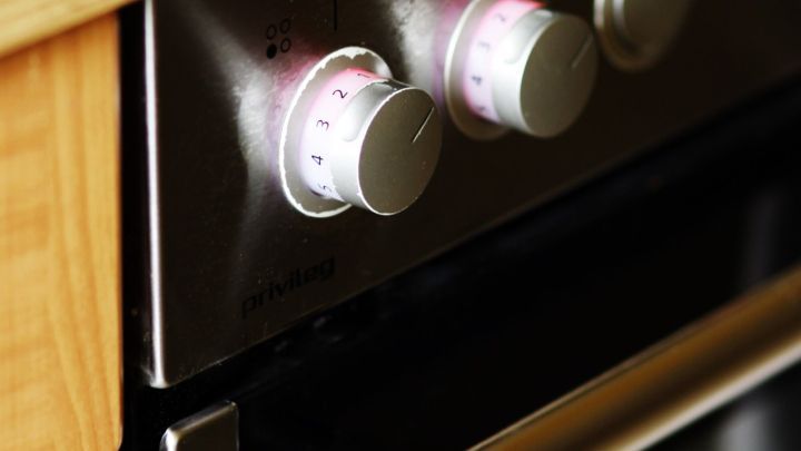 Kn&ouml;pfe eines modernen Herdes leuchten leicht, w&auml;hrend er in einer modernen K&uuml;che eingebaut ist und auf eine Verwendung wartet.