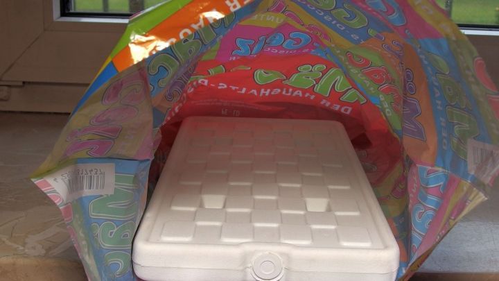 Ein K&uuml;hl-Akku liegt in einer bunten Tragetasche auf einem Tisch, bereit f&uuml;r den Einkauf an einem sonnigen Tag.