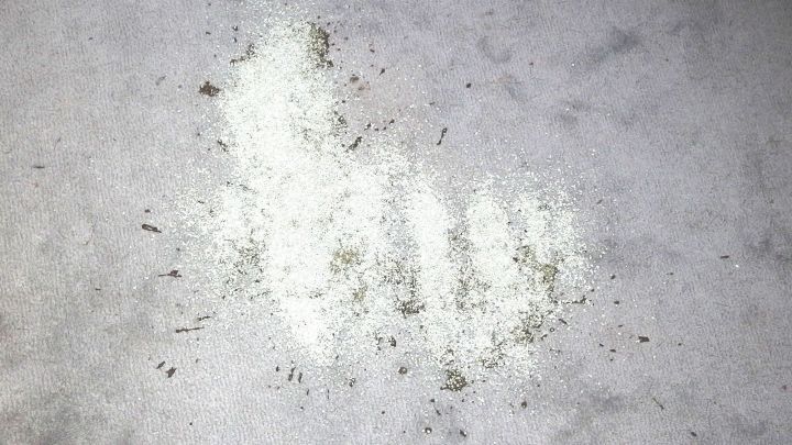 Ein grauer Untergrund zeigt einen schmutzigen Fleck mit &ouml;liger Substanz, die unordentlich verteilt und leicht verschmutzt ist.