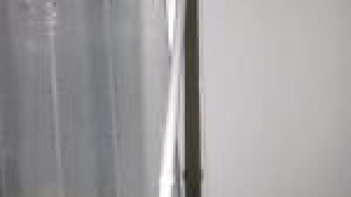 Ein Rollladen mit Kurbelantrieb wird mithilfe eines Akkuschraubers bewegt, w&auml;hrend er an einem Fenster angebracht ist.