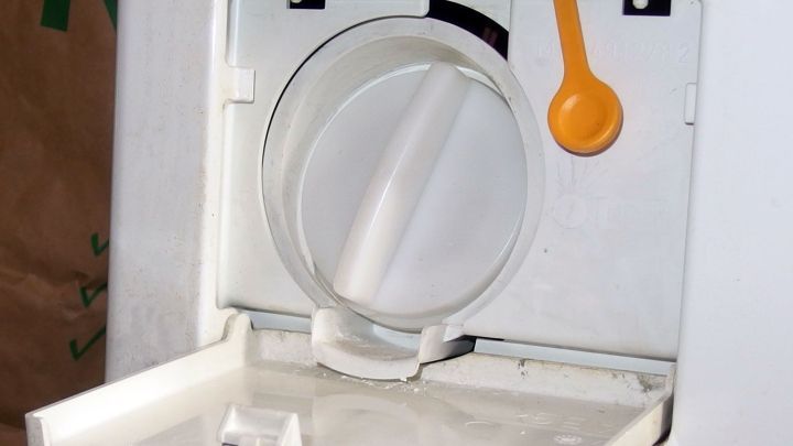 Ein Abflusssystem einer Waschmaschine mit ge&ouml;ffnetem Deckel, bereit zur Reinigung, um M&uuml;ffeln von W&auml;sche zu verhindern.