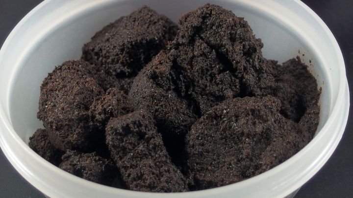 In einer wei&szlig;en Sch&uuml;ssel liegt frischer Kaffeesatz, der zur D&uuml;ngung von Blumen verwendet werden kann, um Pflanzen zu n&auml;hren.