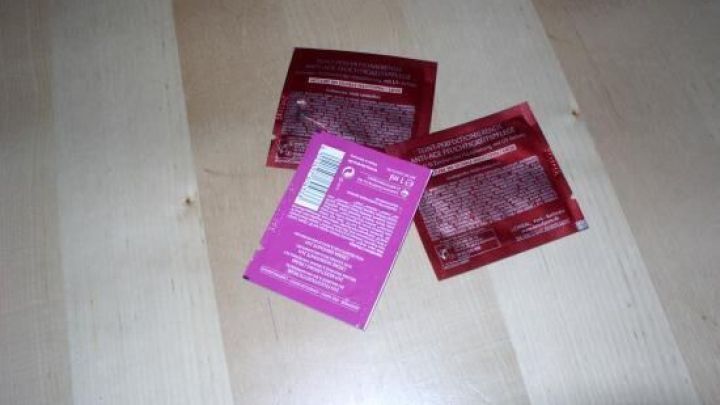 Drei Pflegeproben f&uuml;r Hals und Dekollet&eacute; liegen auf einem hellen Holztisch, bereit zur Anwendung.