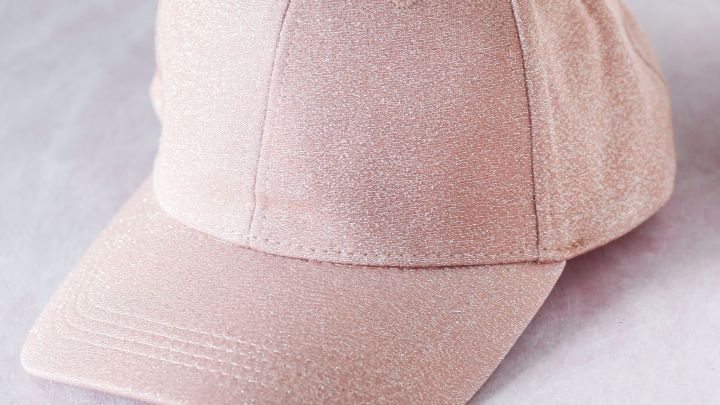 Eine schlichte M&uuml;tze liegt auf einem weichen Untergrund und wirkt m&ouml;glicherweise verschwitzt und verf&auml;rbt.