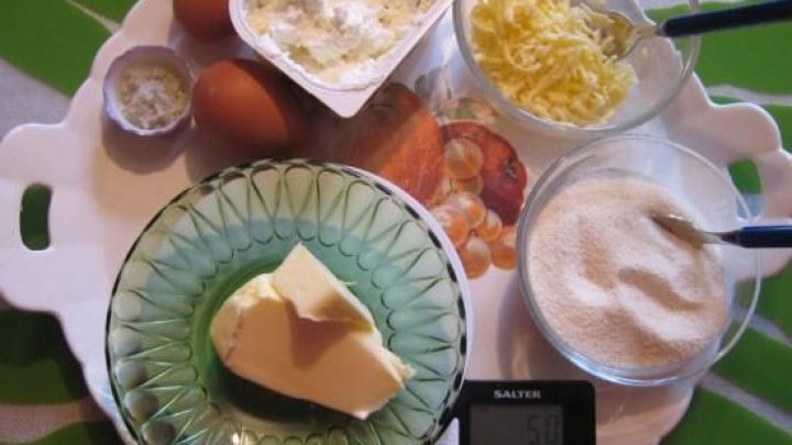 Eine Sammlung von Zutaten f&uuml;r Grie&szlig;kl&ouml;&szlig;chen: Butter, Eier, Quark, Grie&szlig; und Zucker auf einem bunten Tablett.