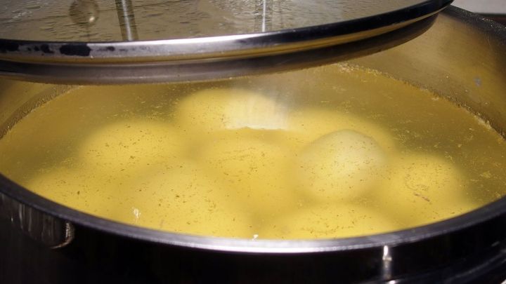 Gekochte Kartoffeln schwimmen in einem Topf mit Kartoffelwasser, um die nahrhaften Inhaltsstoffe zu extrahieren.