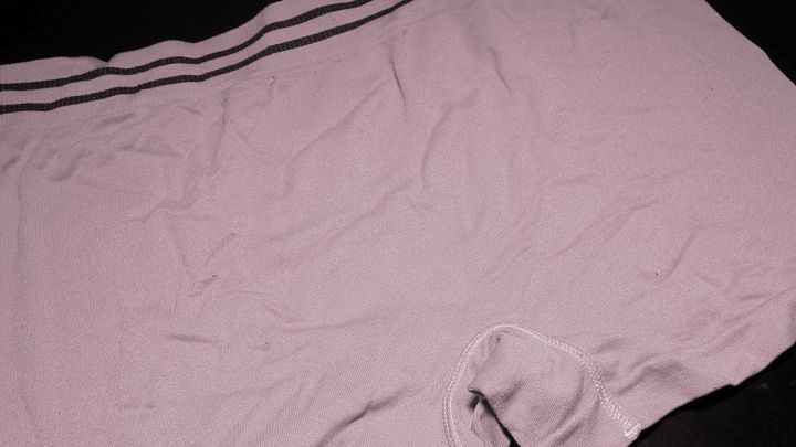 Ein lila Unterw&auml;schest&uuml;ck liegt auf einem schwarzen Hintergrund und zeigt m&ouml;gliche Verf&auml;rbungen von der W&auml;sche.