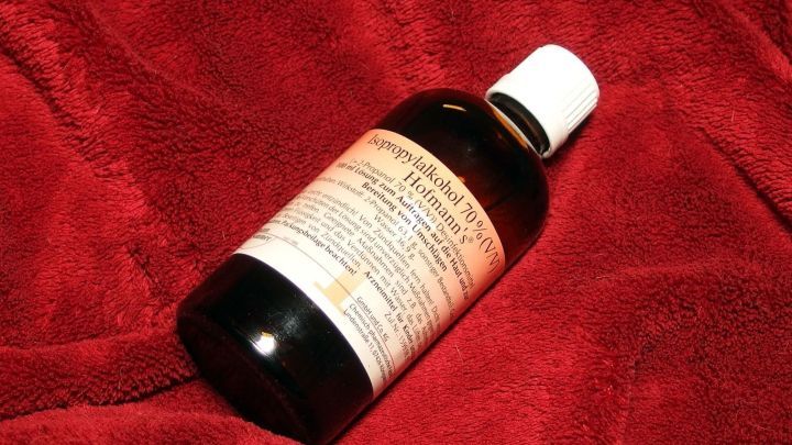 Ein Fl&auml;schchen mit einer Fl&uuml;ssigkeit liegt auf einem roten Hintergrund. Es k&ouml;nnte sich um eine Hilfe gegen Insektenstiche handeln.