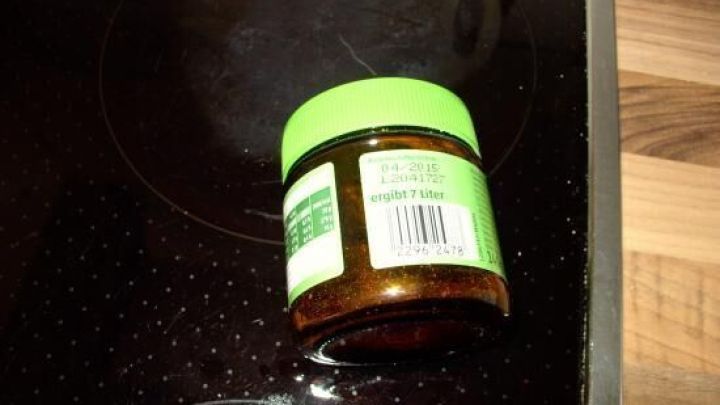 Ein Glas mit getrockneten Kr&auml;utern steht auf einer Kochplatte in einer modernen K&uuml;che, bereit zur Lagerung.