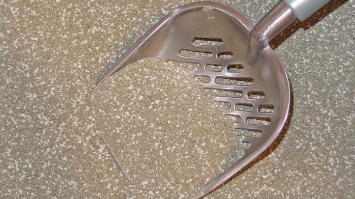 Ein Katzenstreu-Scoop liegt in feinem, gebrauchtem Katzenstreu, das als nat&uuml;rliches M&auml;useabwehrmittel dient.