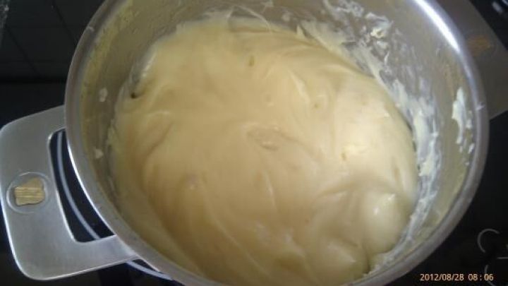 Eine Sch&uuml;ssel mit cremiger Teigmasse sitzt auf einem Herd. Die Masse sieht glatt und gut gemischt aus. Datum: 2012/08/28 08:06.