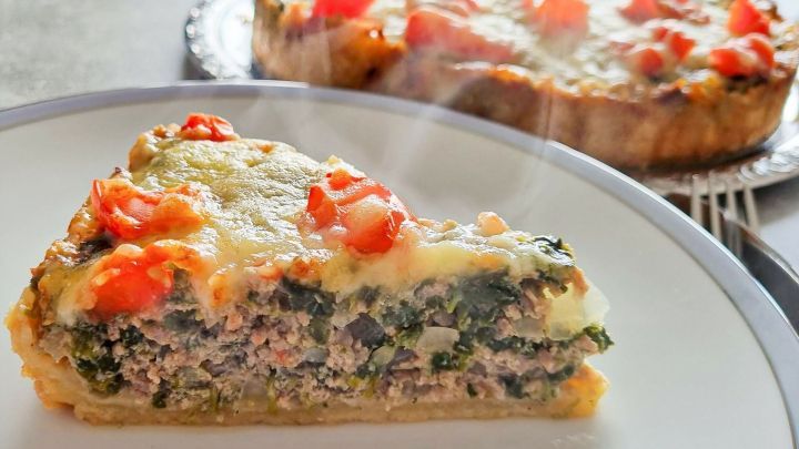 Ein St&uuml;ck Farinata mit Kichererbsen, dampfend serviert auf einem Teller, umgeben von weiteren Portionen im Hintergrund.