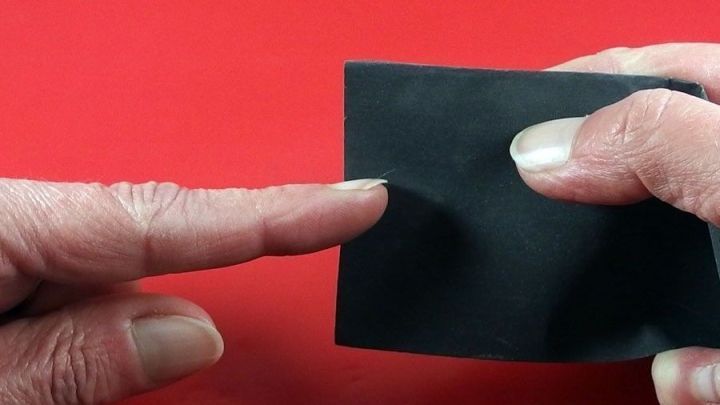 Ein Finger gleitet &uuml;ber eine schwarze Feile, w&auml;hrend ein anderer Finger das Schleifen der N&auml;gel unterst&uuml;tzt.