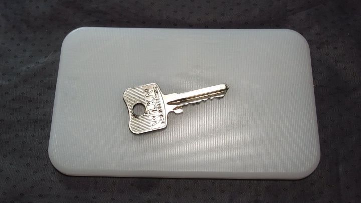 Ein Schl&uuml;ssel liegt auf einem wei&szlig;en Schneidebrett, w&auml;hrend jemand dar&uuml;ber nachdenkt, wie man seine Wohnung reinigen kann.