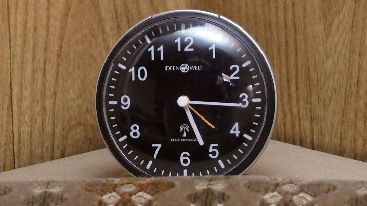 Eine schwarze Wanduhr steht auf einem Tisch und zeigt Zeit an, um den Morgen effizient zu gestalten.