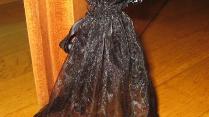 Ein schwarzes S&auml;ckchen aus Stoff liegt am Boden und dient als T&uuml;rstopper, um die T&uuml;r offen zu halten.