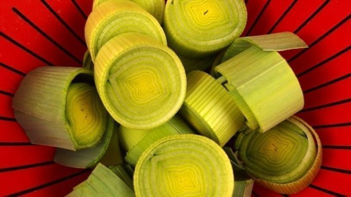 Lauchst&uuml;cke liegen in einem roten Sieb, bereit zum Waschen, um sauber und frisch f&uuml;r die Zubereitung zu sein.