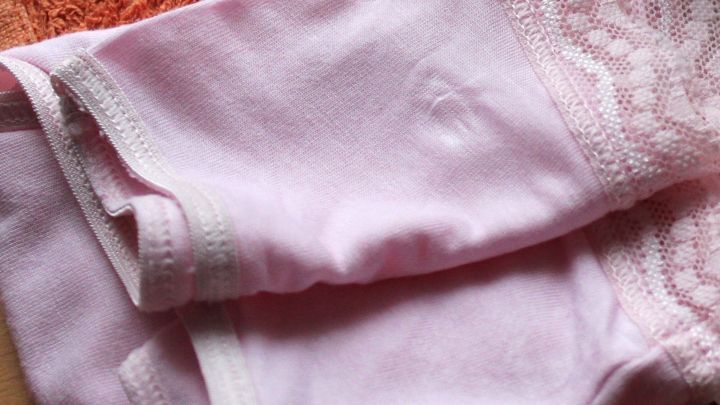 Ein rosa Kopfkissenbezug liegt zusammengefaltet auf einer orangefarbenen Decke und wird zum Schutz der Feinw&auml;sche genutzt.