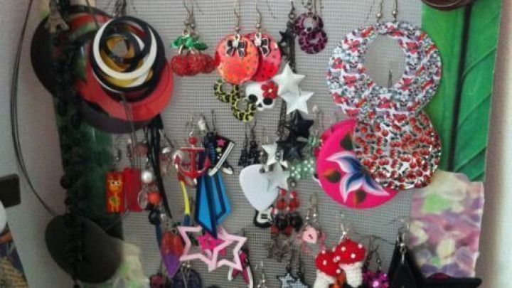 Ein bunter Ohrstecker-Halter zeigt verschiedene Modelle ordentlich angeordnet an einer dekorierten Wand.