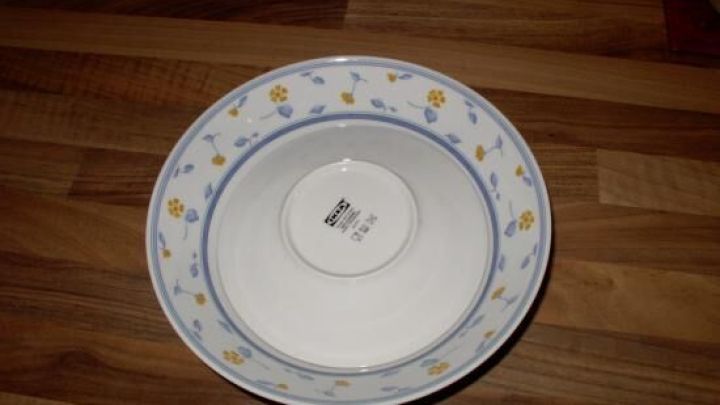 Eine Sch&uuml;ssel mit bluemem Rand steht auf einem Holzoberfl&auml;che, bereit, um Kl&ouml;&szlig;e "trocken" zu halten.