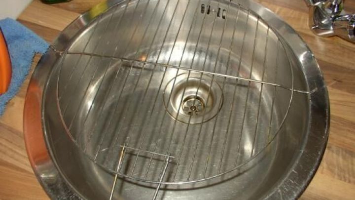 Ein Edelstahl-Sp&uuml;lbecken zeigt eine Rostfl&auml;che, die &uuml;ber dem Abfluss zur professionellen Reinigung angebracht ist.