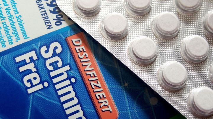 Wei&szlig;e Tabletten und ein Desinfektionsmittel sind nebeneinander auf einer Oberfl&auml;che platziert, was kindersicheres Verwahren verdeutlicht.