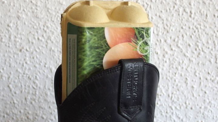 Ein Stiefelschaftstrecker aus einem Eierkarton steckt in einem schwarzen Stiefel, um den Schuh aufzurichten und zu stabilisieren.