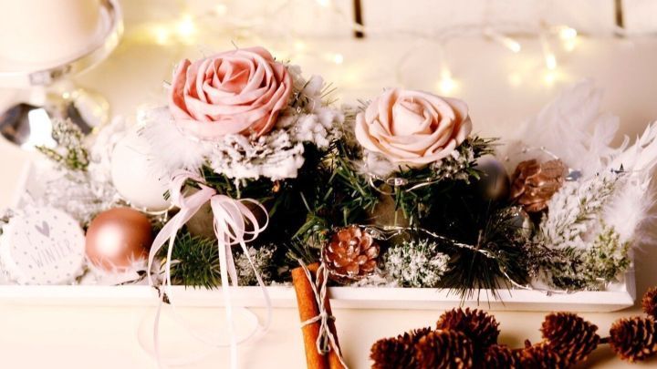 Ein Arrangement aus dekorativen, haltbaren Blumen und Naturmaterialien ist liebevoll in einer Holzschale platziert.