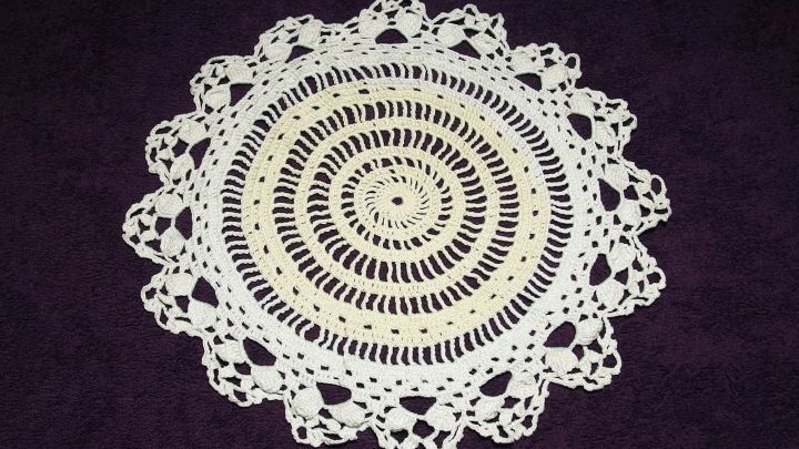 Ein rundes H&auml;keldeckchen liegt flach auf einem dunklen Untergrund, bereit zum St&auml;rken mit Haarspray f&uuml;r mehr Haltbarkeit.