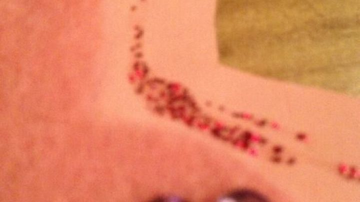 Eine glitzernde Herzkontur mit rotem Glitzerkleber ist auf pinkem Filz platziert, um ein kreatives Bastelprojekt zu zeigen.