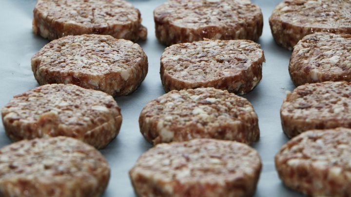 Fleischpattys liegen frisch auf einem Backblech, bereit zum Grillen mit Oberhitze f&uuml;r perfekte Hamburger.