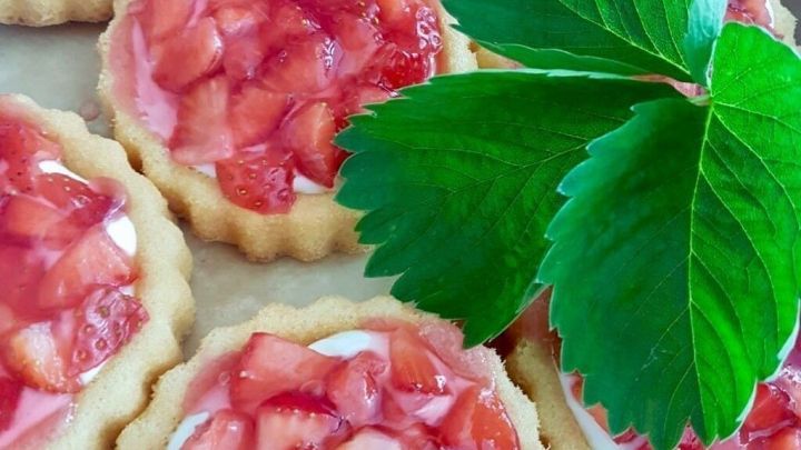 Kleine Blitzt&ouml;rtchen mit frischen Erdbeeren stehen auf einem Blech und warten auf den spontanen Besuch.